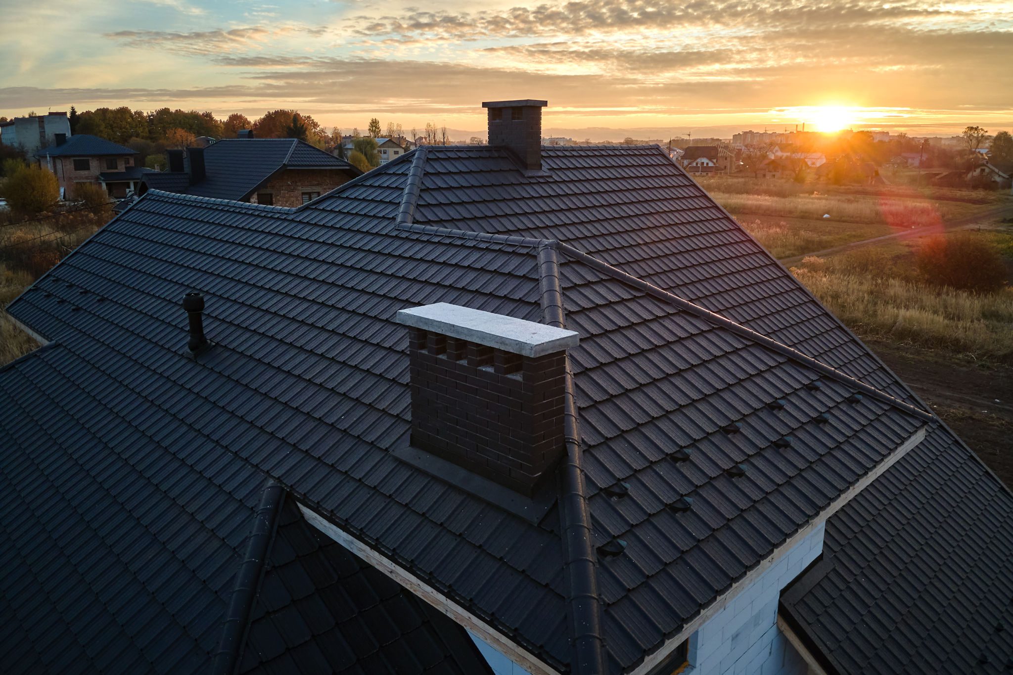 House roof with chimney at sunset.